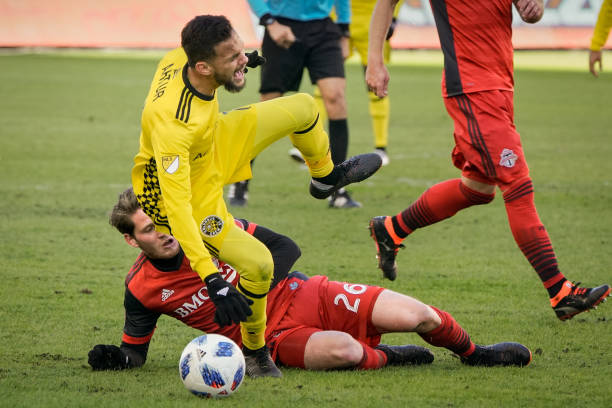 Columbus vs Toronto football players in action during an intense game moment.